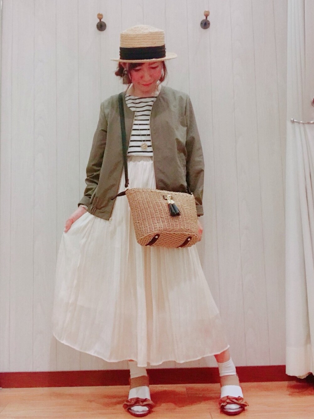 グリーン系のブルゾン、ブラック系のTシャツ/カットソー、ベージュ系のスカートを着用したレディースの春コーディネートの1枚目の写真