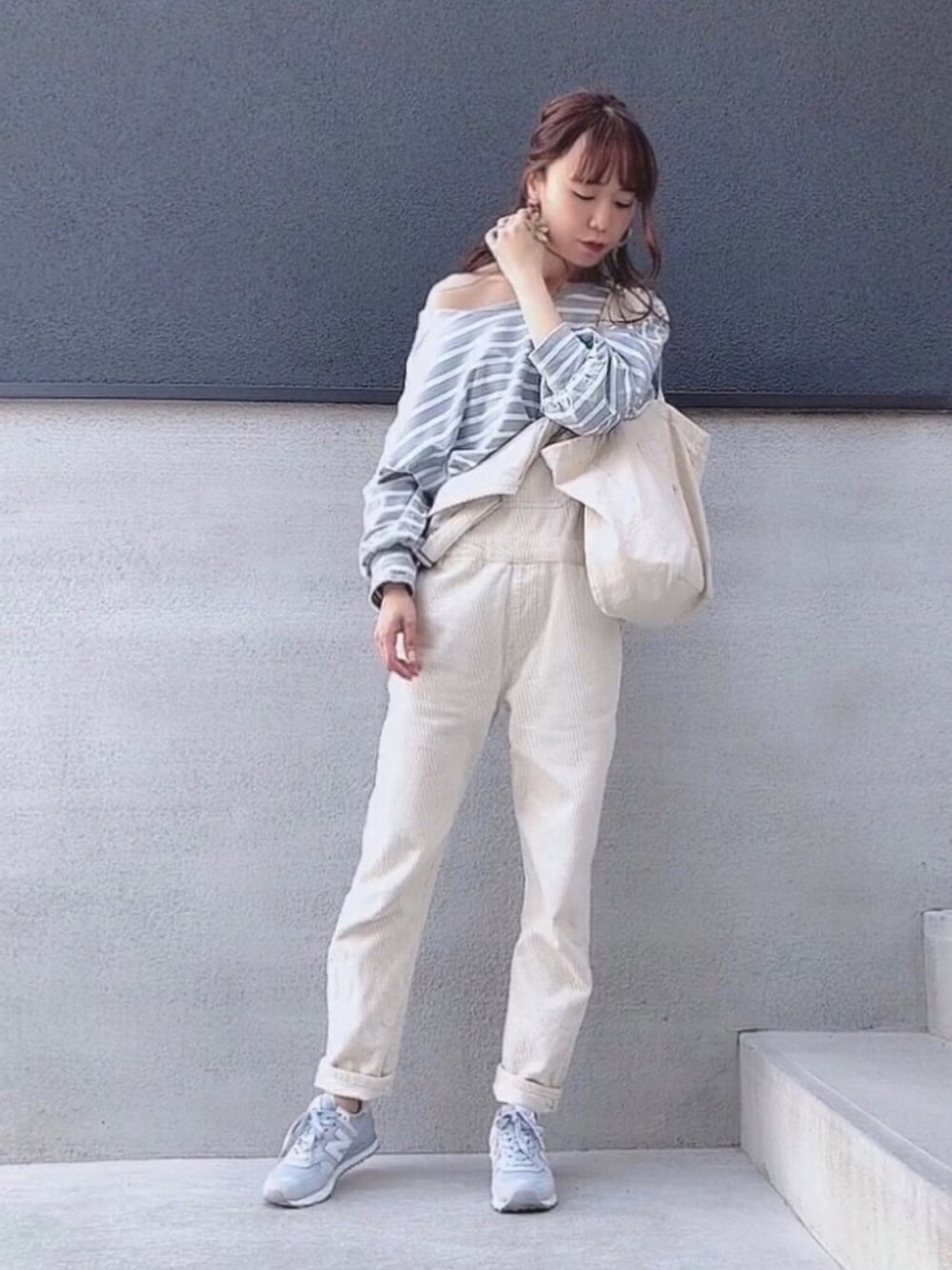 ブルー系のTシャツ/カットソー、ベージュ系のサロペット/オーバーオール、グレー系のスニーカーを着用したレディースの春コーディネートの1枚目の写真