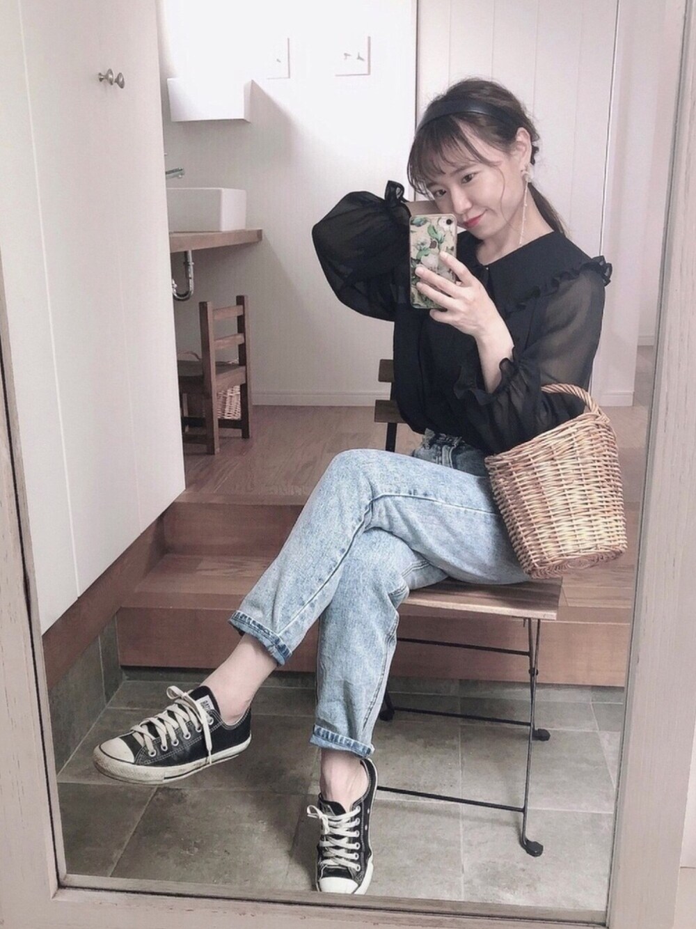 ブルー系のデニムパンツ、ブラック系のスニーカー、ブラック系のシャツ/ブラウスを着用したレディースの春コーディネートの1枚目の写真