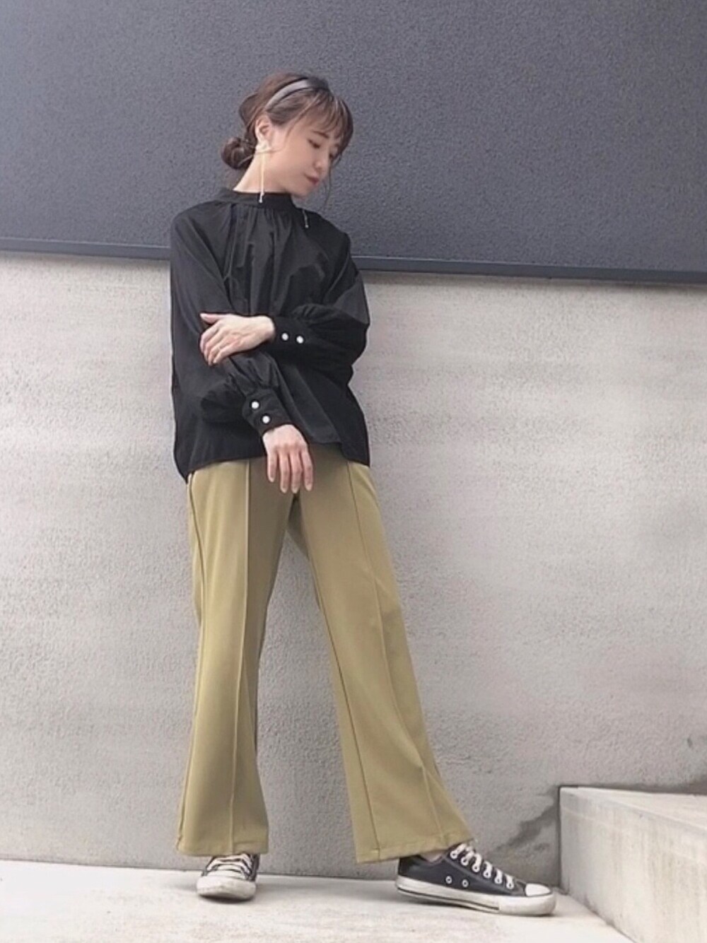 グリーン系のパンツ、ブラック系のスニーカー、ブラック系のシャツ/ブラウスを着用したレディースの春コーディネートの1枚目の写真