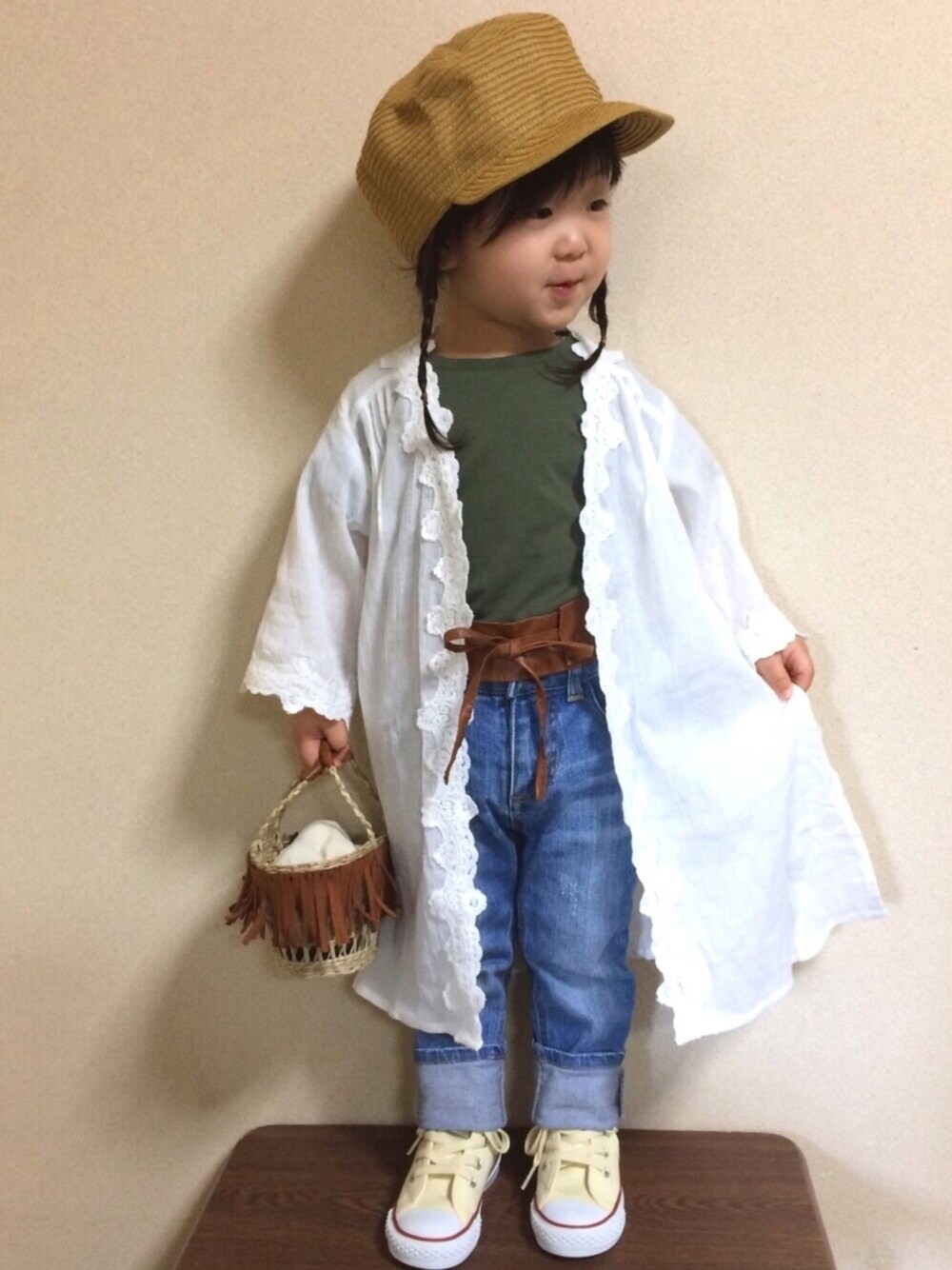 ホワイト系のカーディガン/ボレロ、グリーン系のTシャツ/カットソー、ブルー系のデニムパンツを着用したキッズの春コーディネートの1枚目の写真