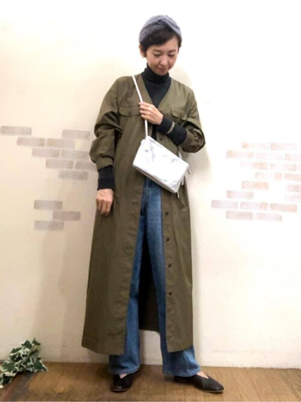 グリーン系のワンピース、グレー系のTシャツ/カットソー、シルバー系のショルダーバッグを着用したレディースの秋コーディネートの1枚目の写真