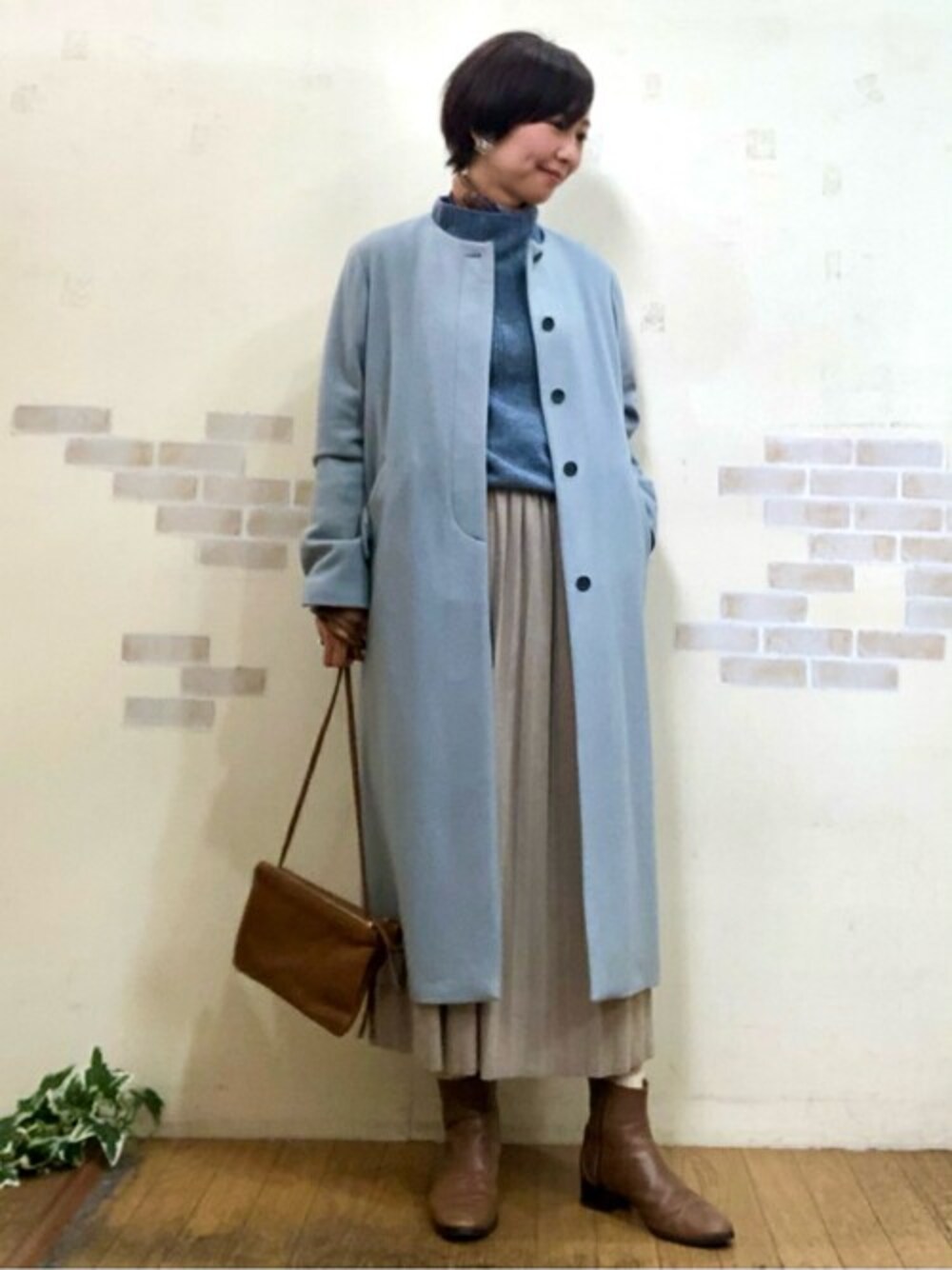 ブルー系のその他アウター、ブルー系のニット/セーター、ベージュ系のスカートを着用したレディースの冬コーディネートの1枚目の写真