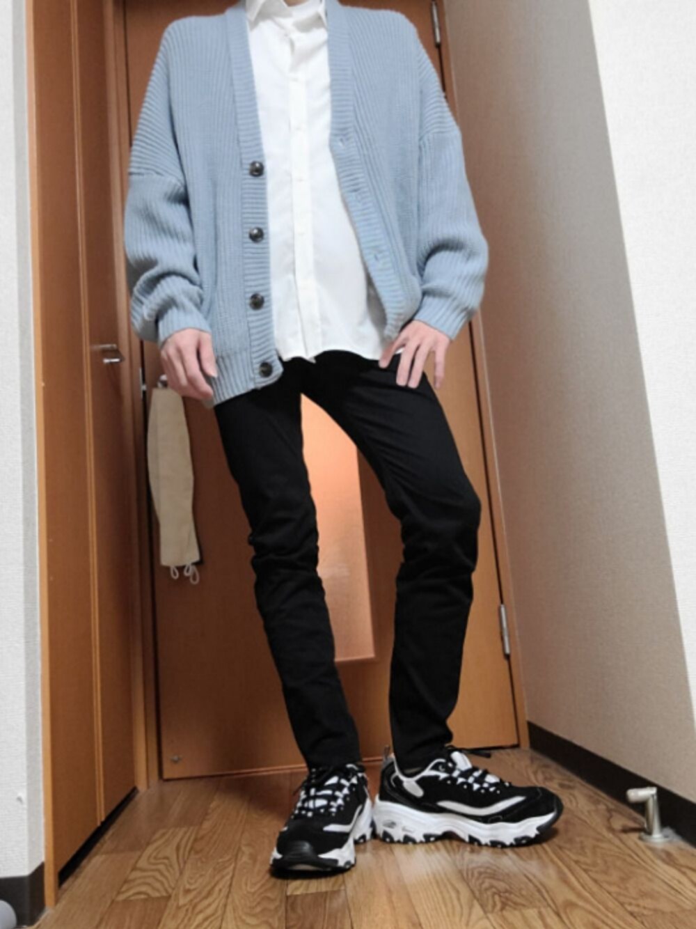 ブルー系のニット/セーター、ホワイト系のシャツ/ブラウス、ブラック系のパンツを着用したメンズの春コーディネートの1枚目の写真