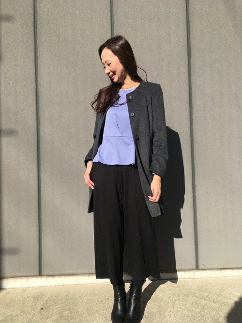 ブルー系のTシャツ/カットソー、グレー系のステンカラーコート、ブラック系のその他パンツを着用したレディースの冬コーディネートの1枚目の写真