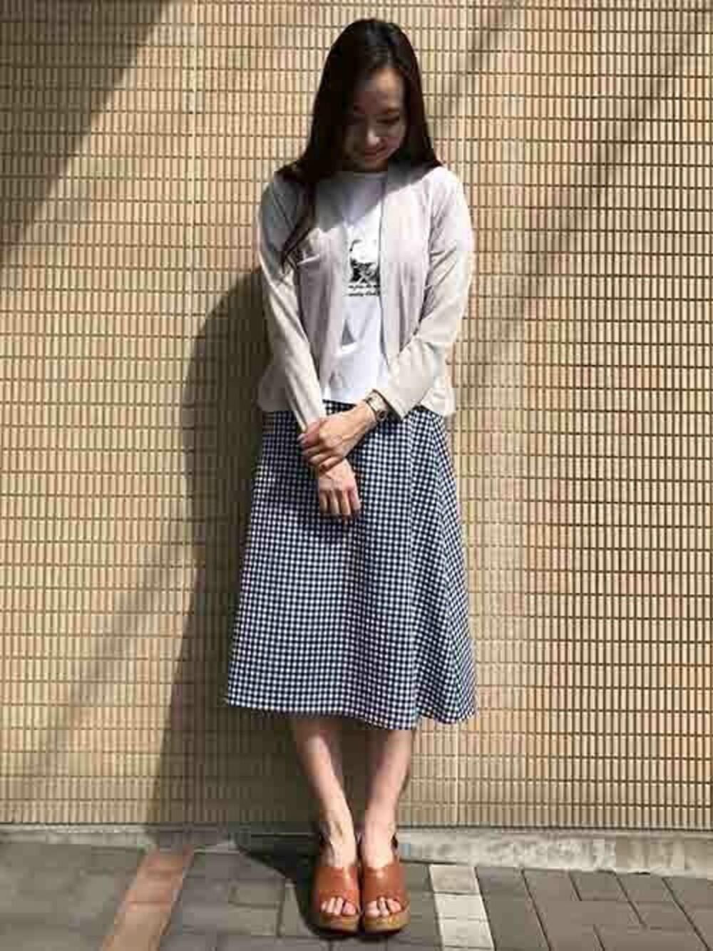 グレー系のカーディガン/ボレロ、ホワイト系のTシャツ/カットソー、ブルー系のスカートを着用したレディースの夏コーディネートの1枚目の写真