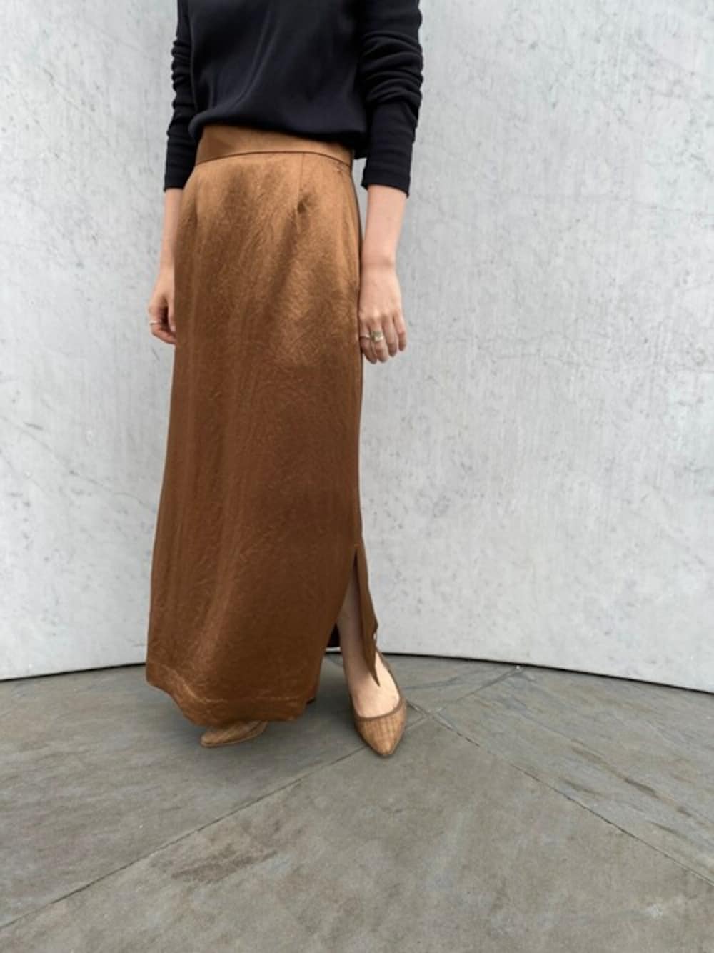 イエロー系のスカートを着用したレディースの秋コーディネートの1枚目の写真