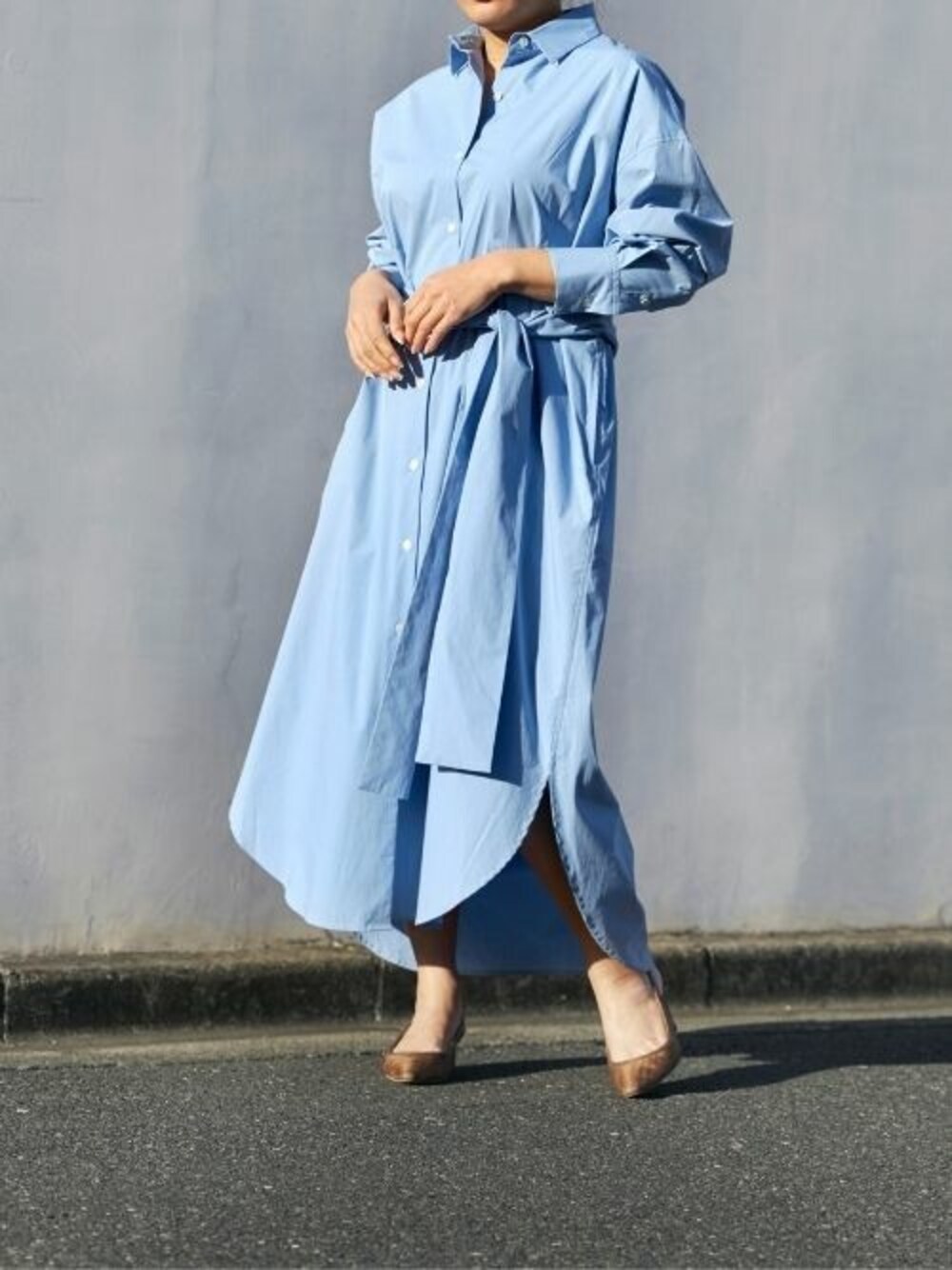 ブルー系のシャツワンピースを着用したレディースの春コーディネートの1枚目の写真