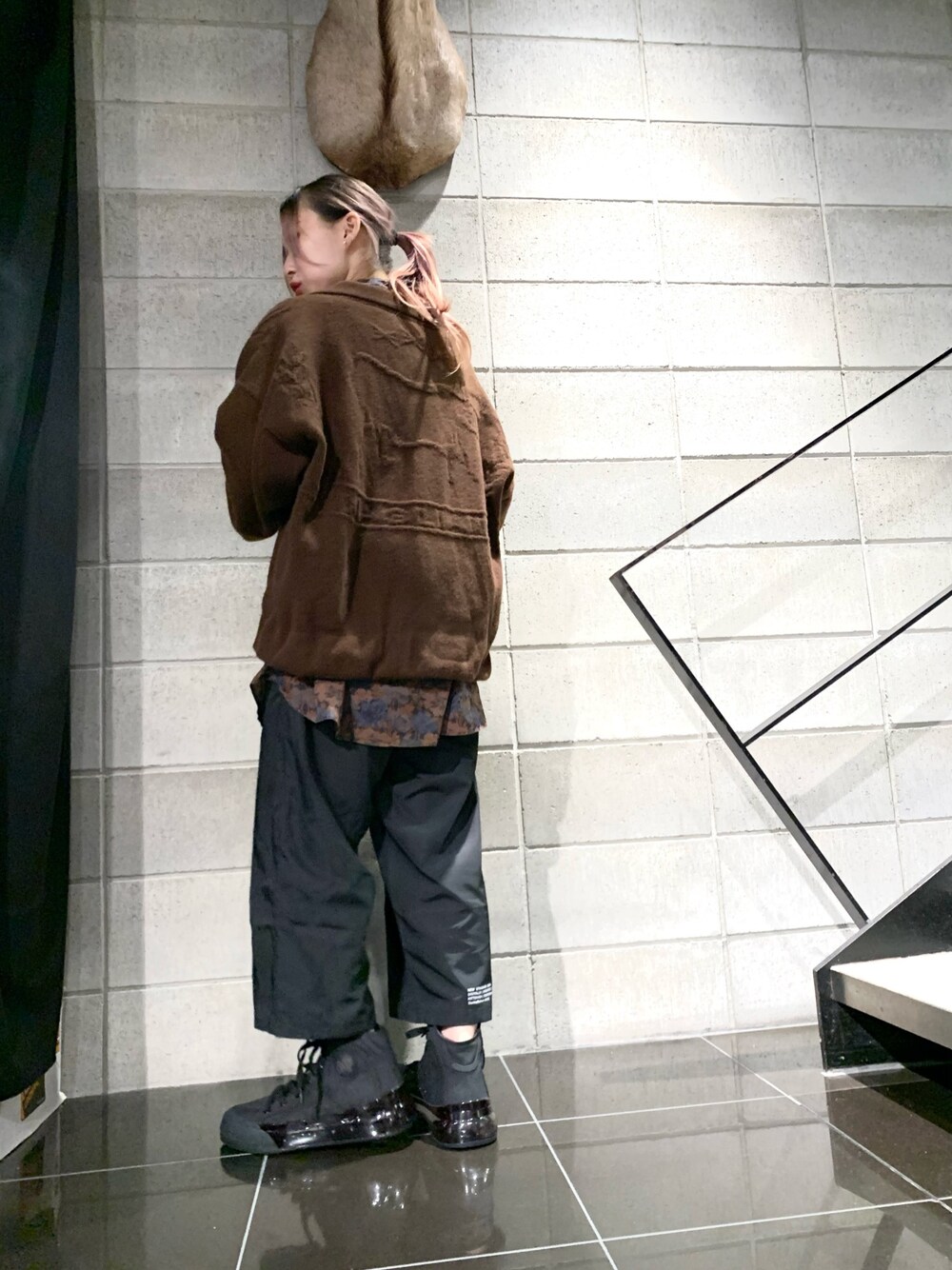 ブラック系のその他パンツ、ブラック系のスニーカー、ブラウン系のニット/セーターを着用したレディースの秋コーディネートの1枚目の写真