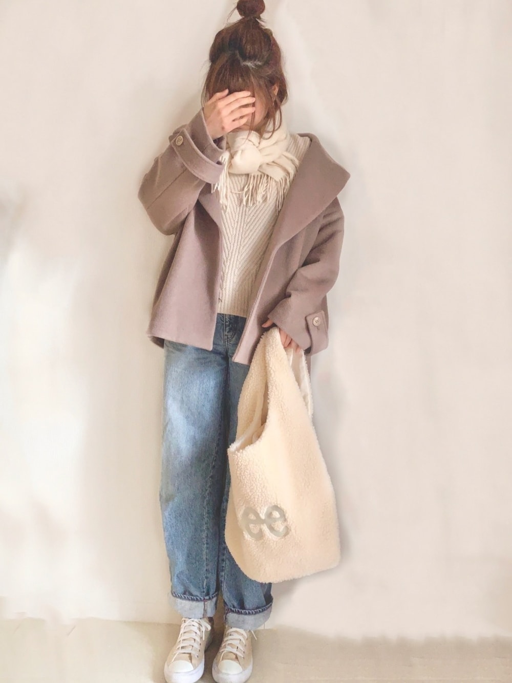 ベージュ系のその他アウター、ベージュ系のニット/セーター、ブルー系のデニムパンツを着用したレディースの冬コーディネートの1枚目の写真