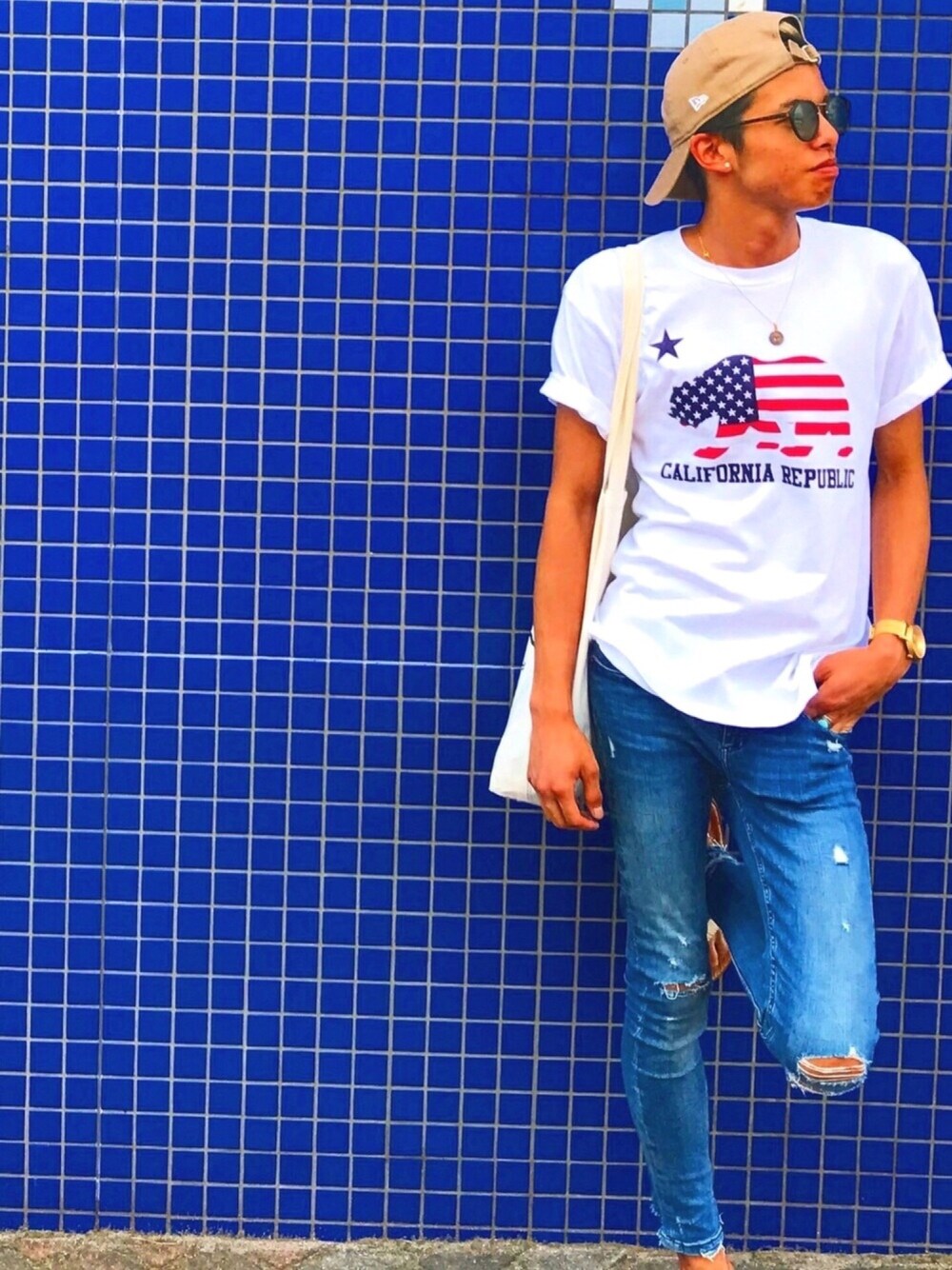 ブルー系のデニムパンツ、ホワイト系のTシャツ/カットソー、ベージュ系のサンダルを着用したメンズの夏コーディネートの1枚目の写真