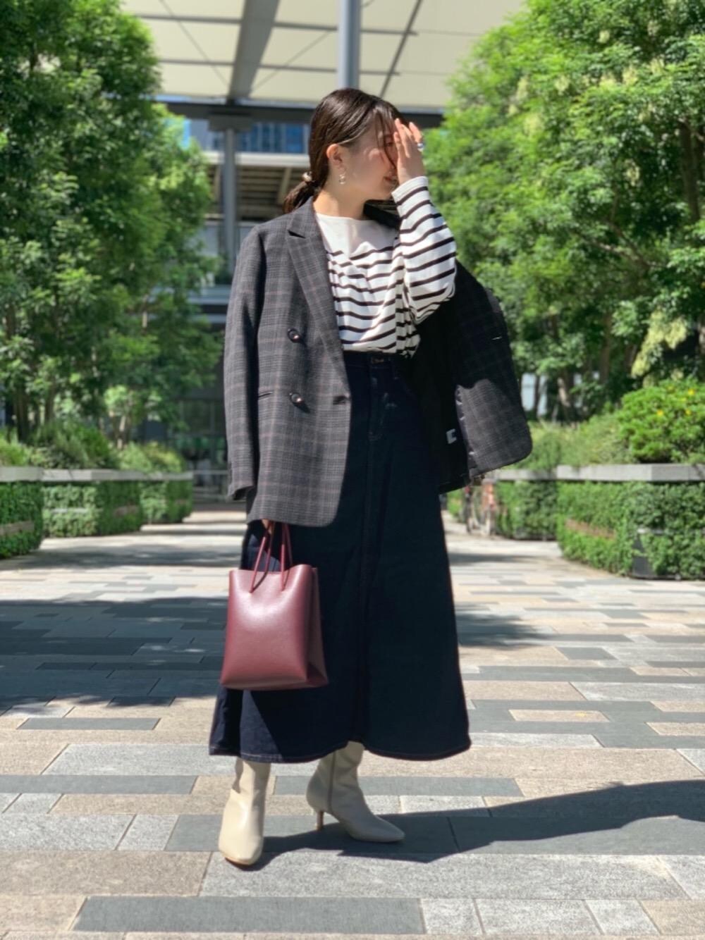 ブルー系のデニムスカート、ホワイト系のTシャツ/カットソー、レッド系のショルダーバッグを着用したレディースの秋コーディネートの1枚目の写真