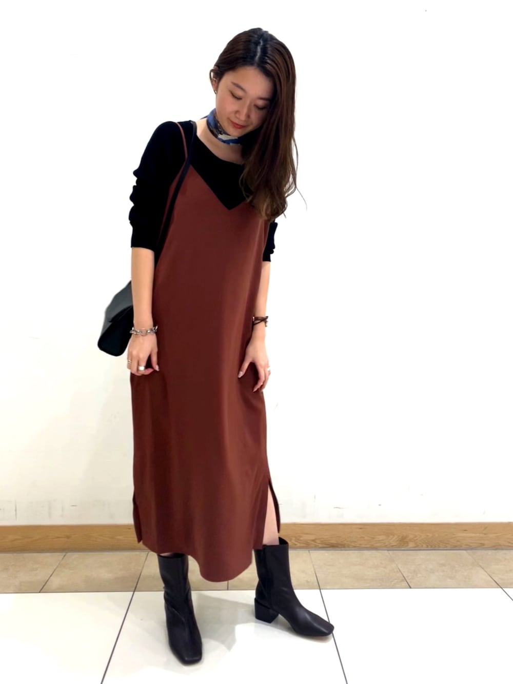 ブラウン系のワンピース、ブラック系のニット/セーター、ブラウン系のブーツを着用したレディースの夏コーディネートの1枚目の写真