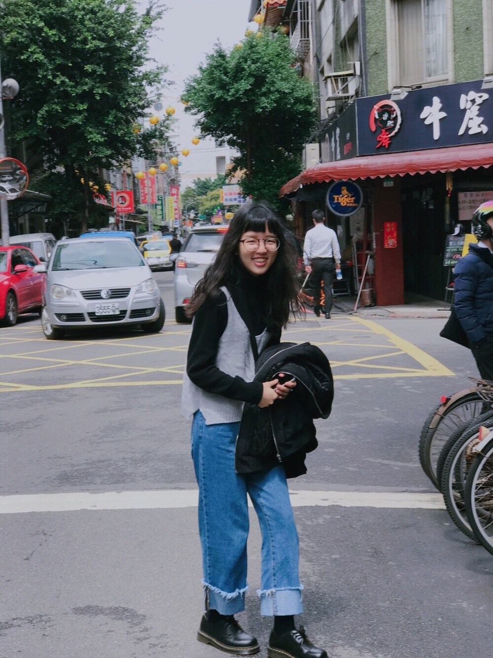 ブラック系のシューズ、シルバー系のベストを着用したレディースの春コーディネートの1枚目の写真