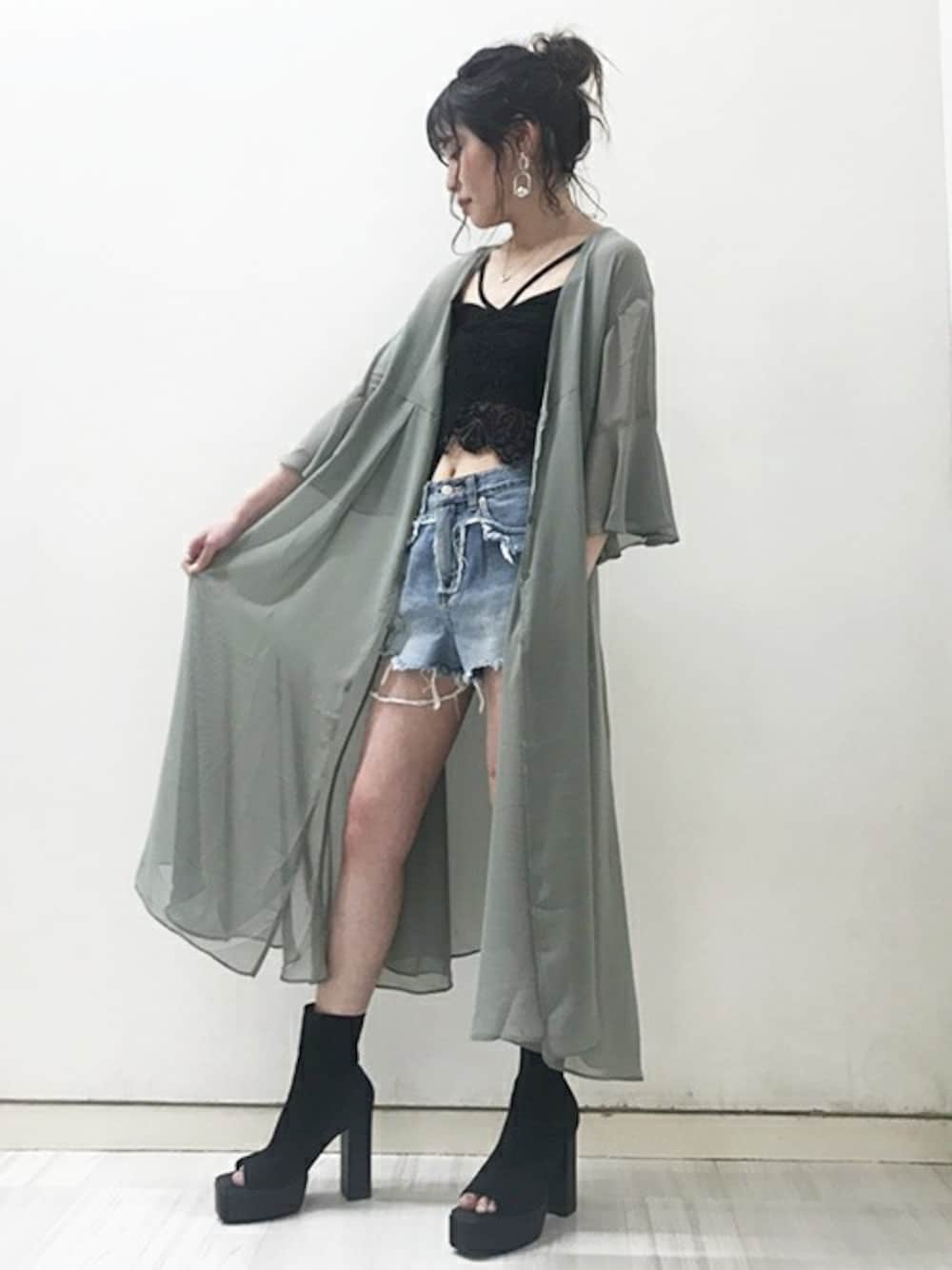 グリーン系のワンピース、ブラック系のキャミソール、ブルー系のデニムパンツを着用したレディースの春コーディネートの1枚目の写真