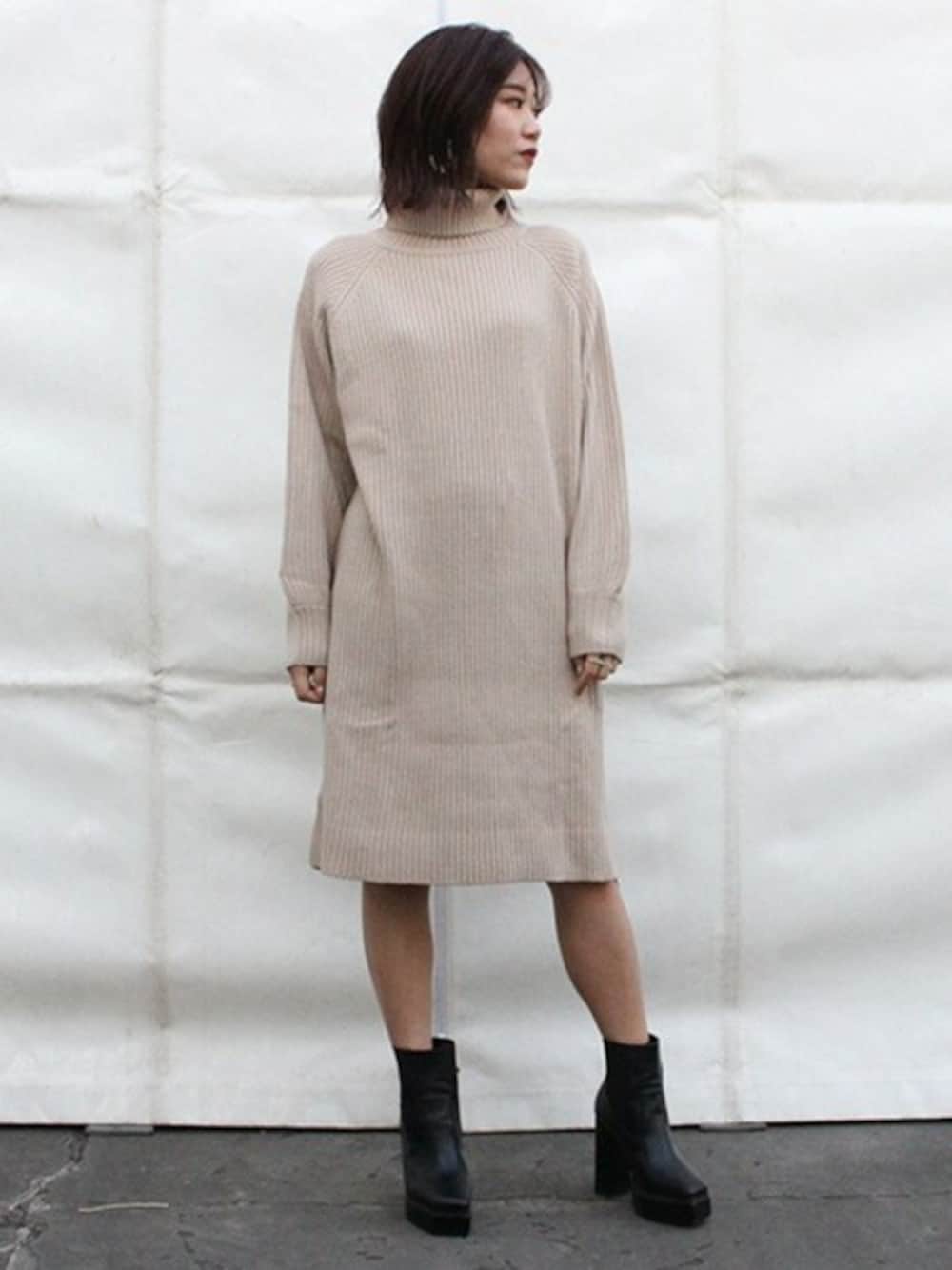 ベージュ系のワンピース、ブラック系のブーツを着用したレディースの冬コーディネートの1枚目の写真
