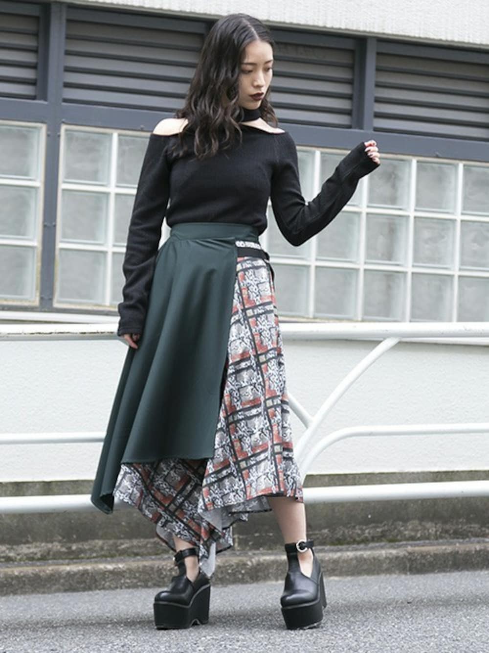 ブラック系のTシャツ/カットソー、グリーン系のスカート、ブラック系のブーティを着用したレディースの秋コーディネートの1枚目の写真