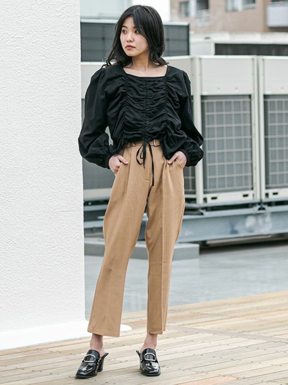 ブラック系のローファー、ベージュ系のスラックス、ブラック系のシャツ/ブラウスを着用したレディースの冬コーディネートの1枚目の写真