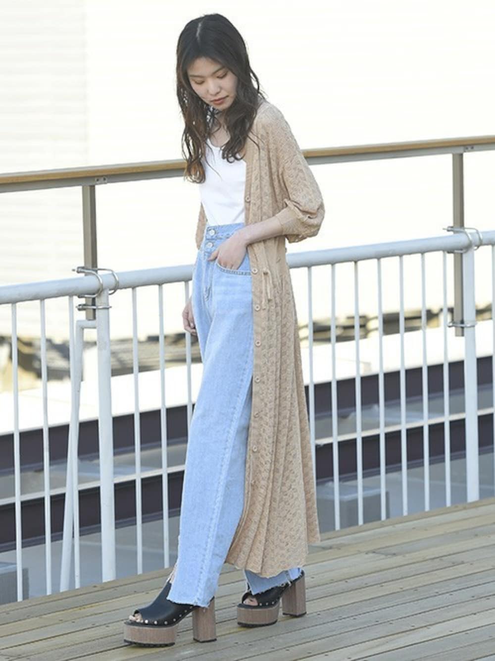 ブルー系のデニムパンツ、ホワイト系のキャミソール、ブラック系のサンダルを着用したレディースの春コーディネートの1枚目の写真