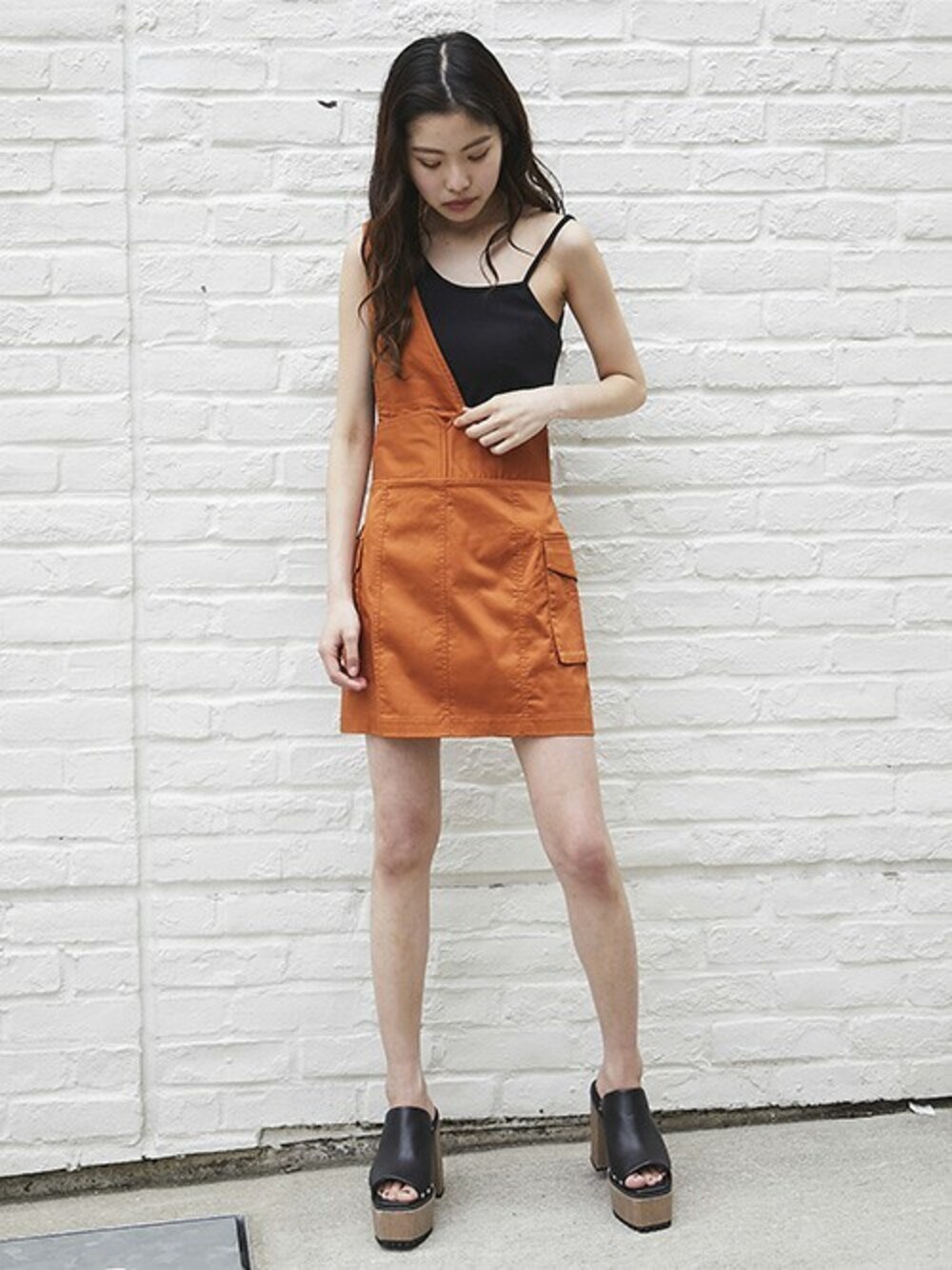 オレンジ系のスカート、ブラック系のキャミソール、ブラック系のサンダルを着用したレディースの夏コーディネートの1枚目の写真