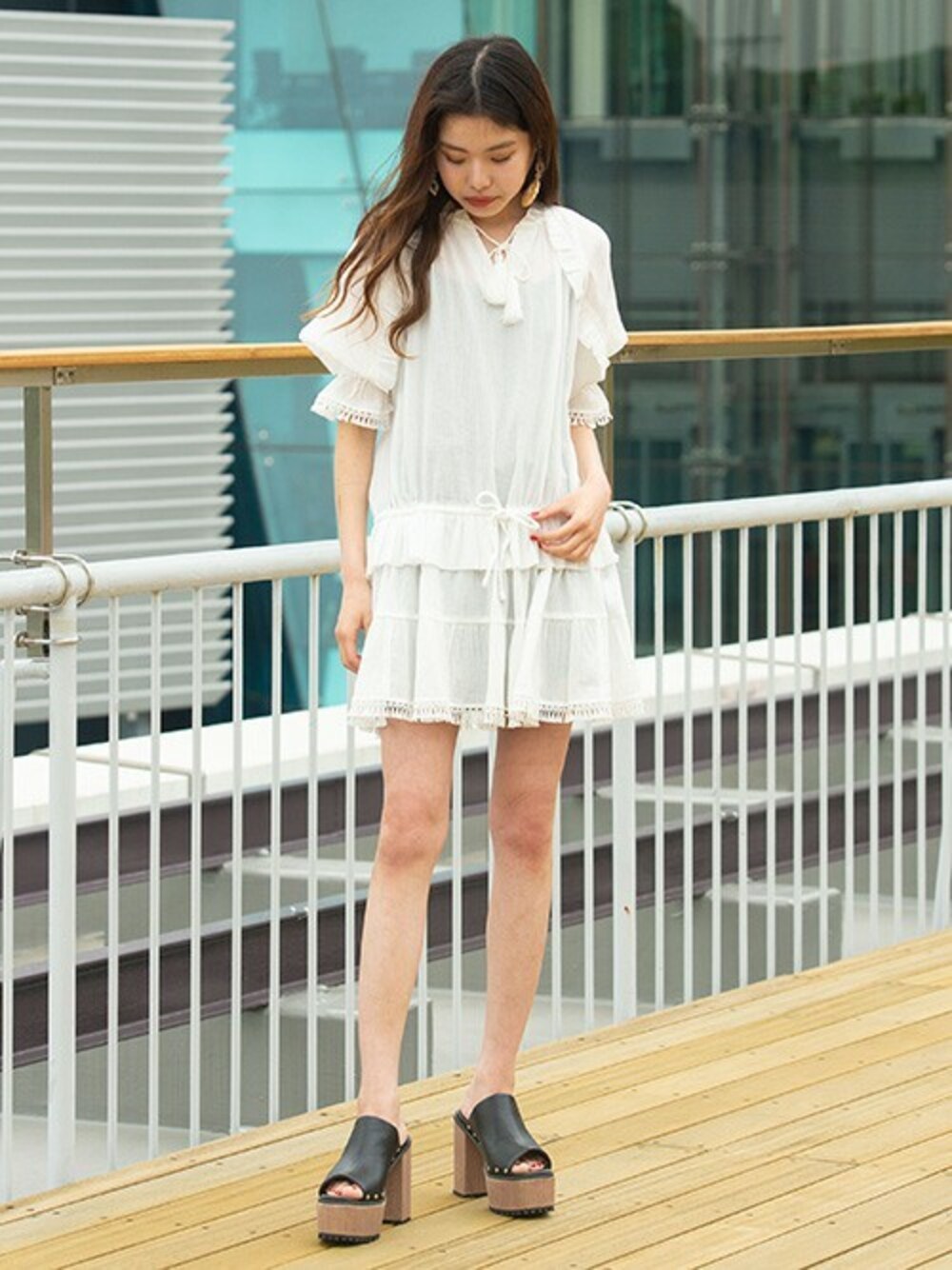 ホワイト系のワンピース、ブラック系のサンダルを着用したレディースの夏コーディネートの1枚目の写真