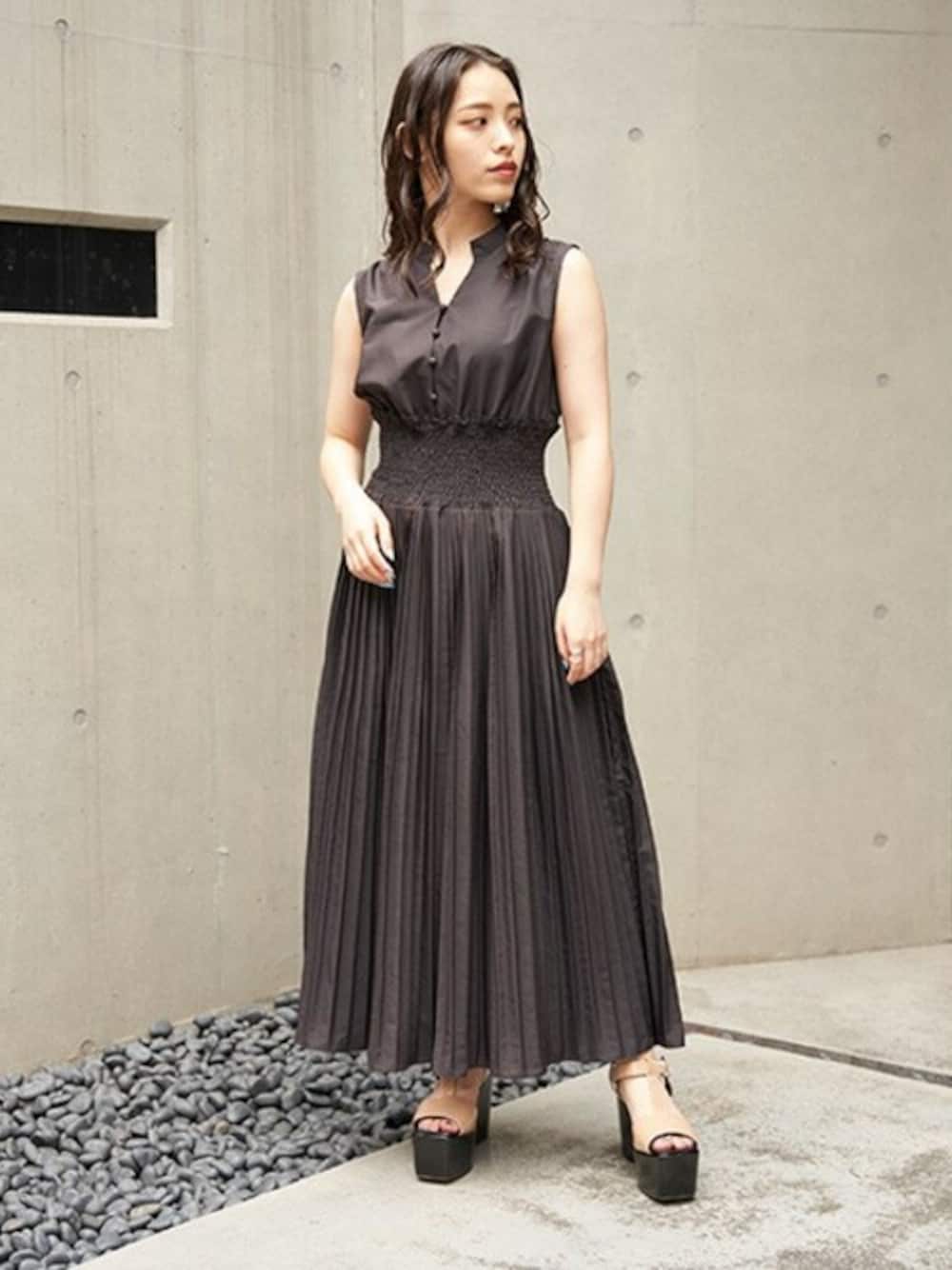 ベージュ系のサンダル、ブラック系のワンピースを着用したレディースの夏コーディネートの1枚目の写真