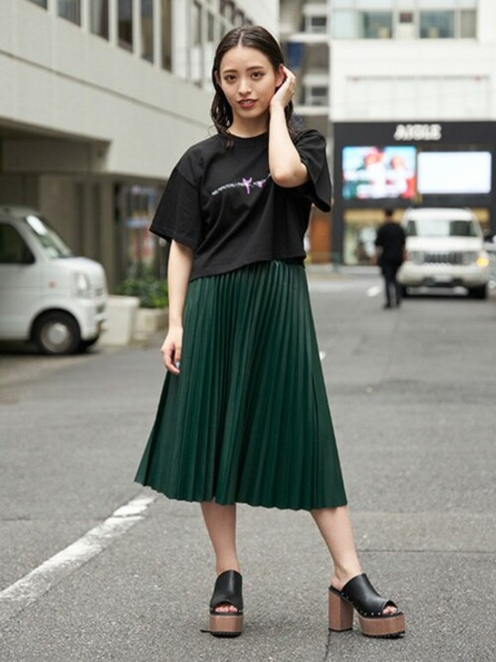 ブラック系のTシャツ/カットソー、ブラック系のサンダル、グリーン系のスカートを着用したレディースの夏コーディネートの1枚目の写真