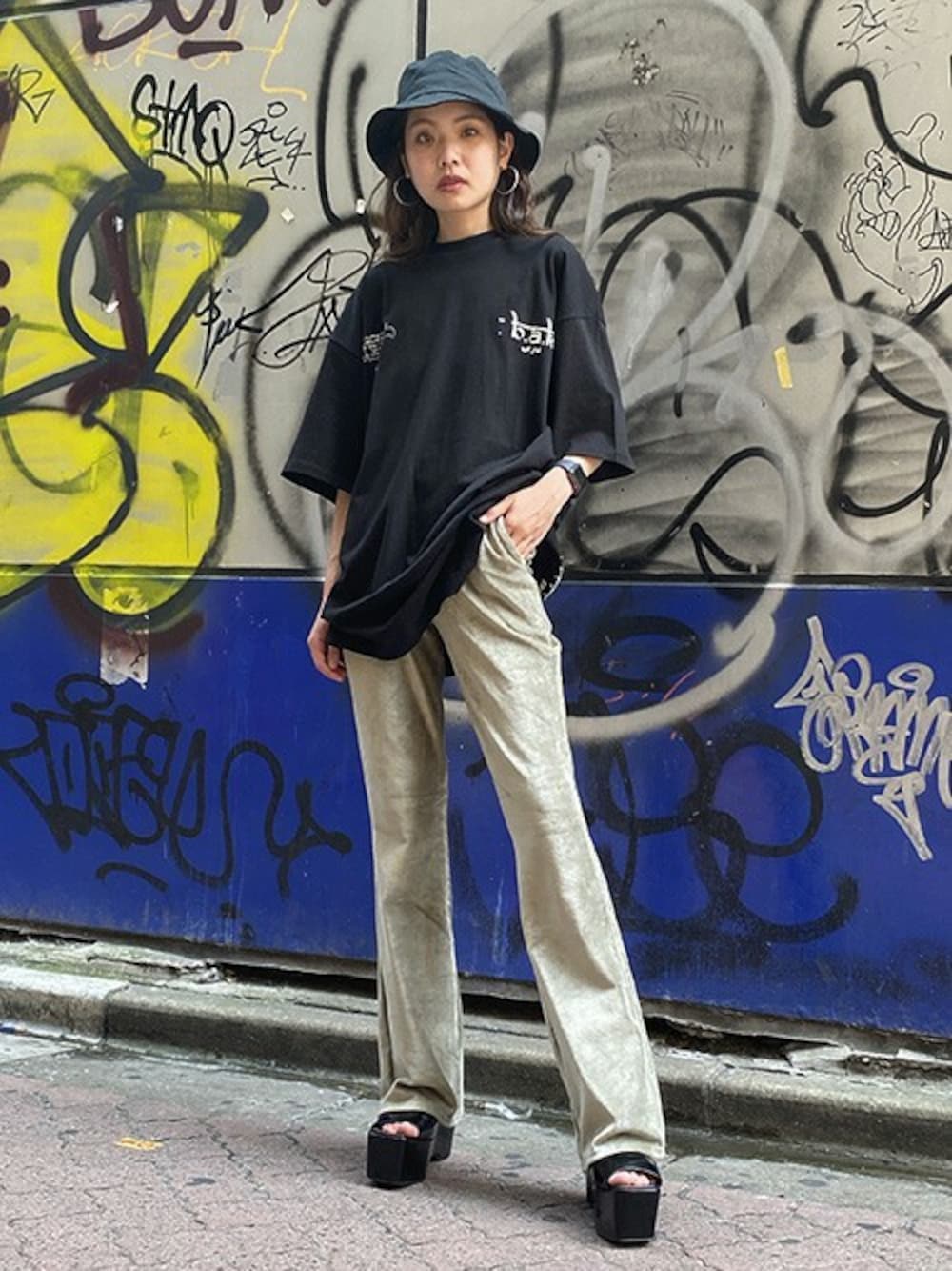 ブラック系のTシャツ/カットソー、グリーン系のその他パンツ、ブラック系のハットを着用したレディースの秋コーディネートの1枚目の写真