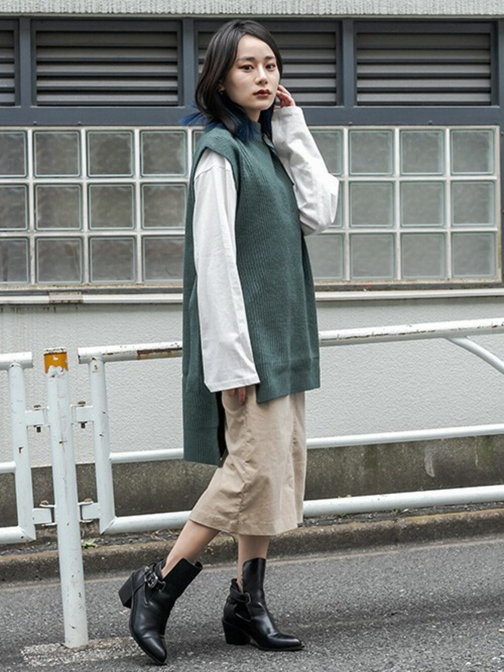 ベージュ系のスカート、グリーン系のベスト、ホワイト系のTシャツ/カットソーを着用したレディースの秋コーディネートの1枚目の写真