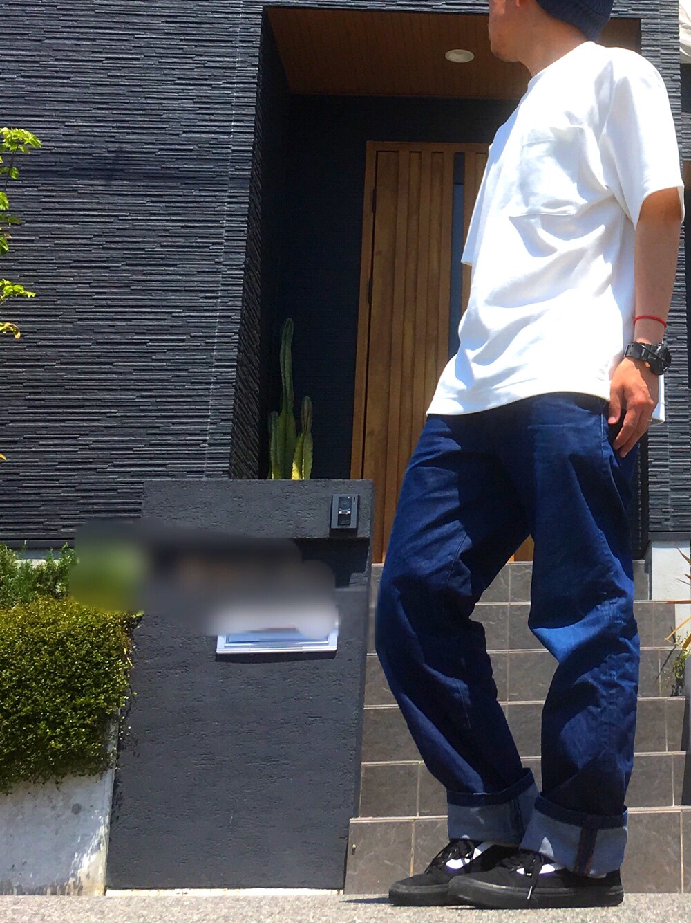 ブルー系のデニムパンツ、ホワイト系のTシャツ/カットソー、ブラック系のスニーカーを着用したメンズの春コーディネートの1枚目の写真