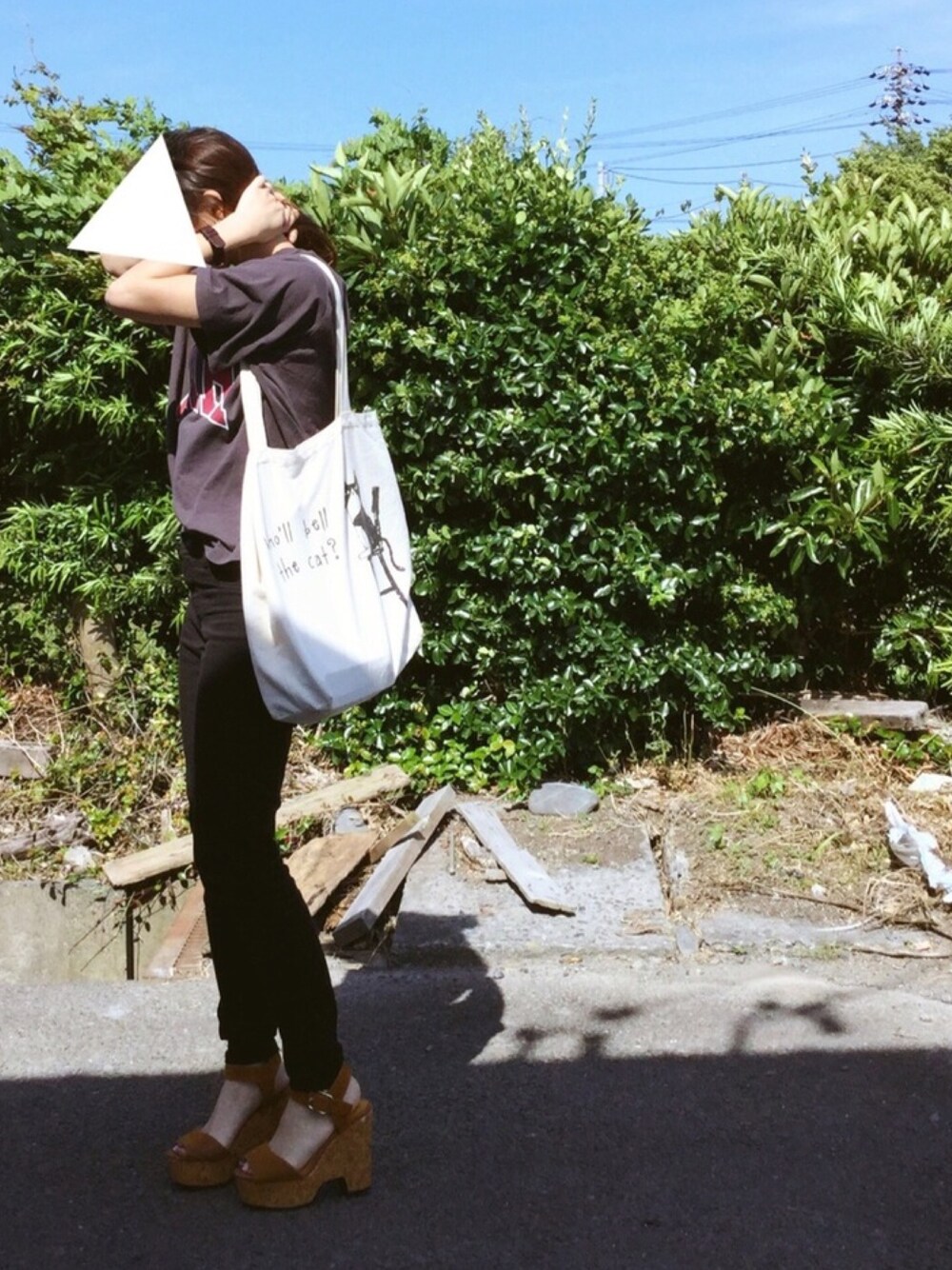 グレー系のTシャツ/カットソー、ベージュ系のトートバッグ、ブラック系のパンツを着用したレディースの夏コーディネートの1枚目の写真