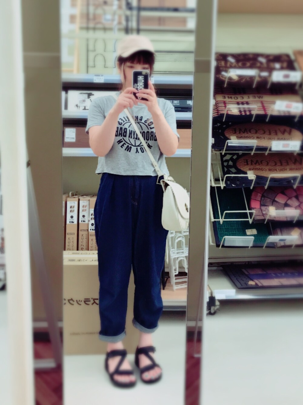 ブルー系のデニムパンツ、グレー系のTシャツ/カットソー、ホワイト系のショルダーバッグを着用したレディースの夏コーディネートの1枚目の写真