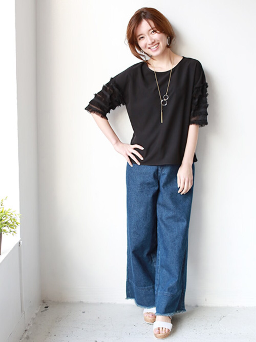 ブラック系のシャツ/ブラウス、ブルー系のデニムパンツを着用したレディースの春コーディネートの1枚目の写真