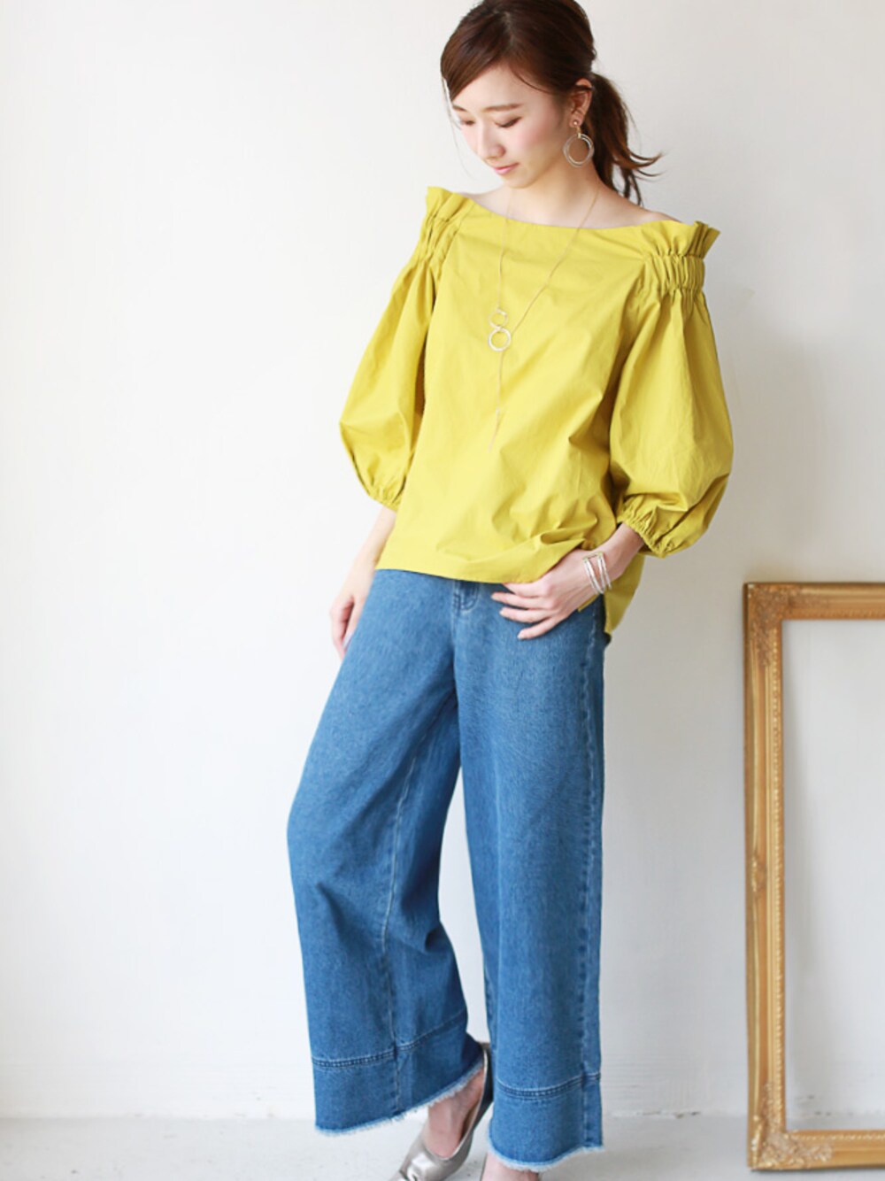イエロー系のシャツ/ブラウス、ブルー系のデニムパンツを着用したレディースの夏コーディネートの1枚目の写真