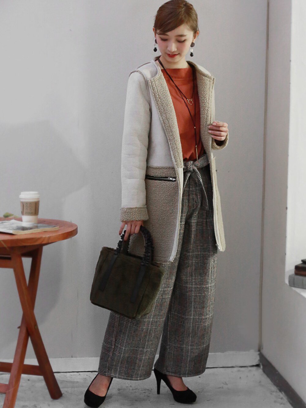 ベージュ系のムートンコート、オレンジ系のその他パンツ、グレー系のトートバッグを着用したレディースの秋コーディネートの1枚目の写真
