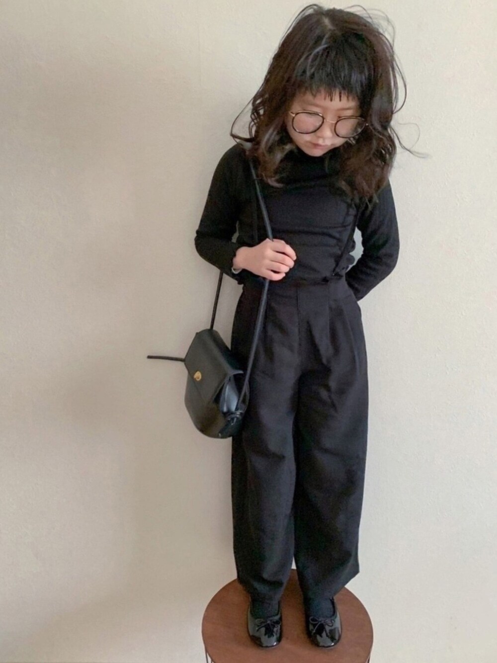 ブラック系のトップス、ブラック系のサロペット/オーバーオール、ブラック系のバレエシューズを着用したキッズの春コーディネートの1枚目の写真
