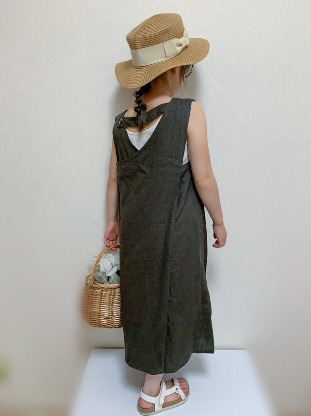 グレー系のワンピース、ベージュ系のバッグ、ホワイト系のタンクトップを着用したキッズの夏コーディネートの1枚目の写真