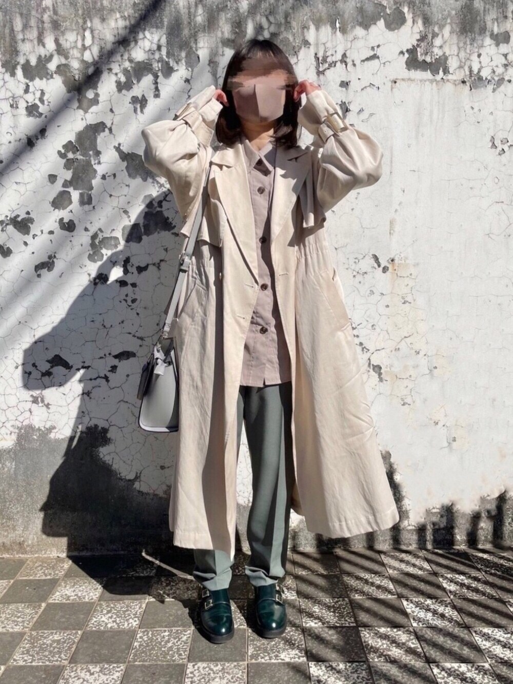 ベージュ系のトレンチコート、ホワイト系のシャツ/ブラウス、グリーン系のその他パンツを着用したレディースの冬コーディネートの1枚目の写真