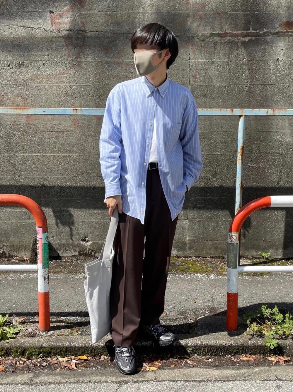 ブルー系のシャツ/ブラウス、ブラウン系のスラックス、ブラック系のスニーカーを着用したメンズの春コーディネートの1枚目の写真