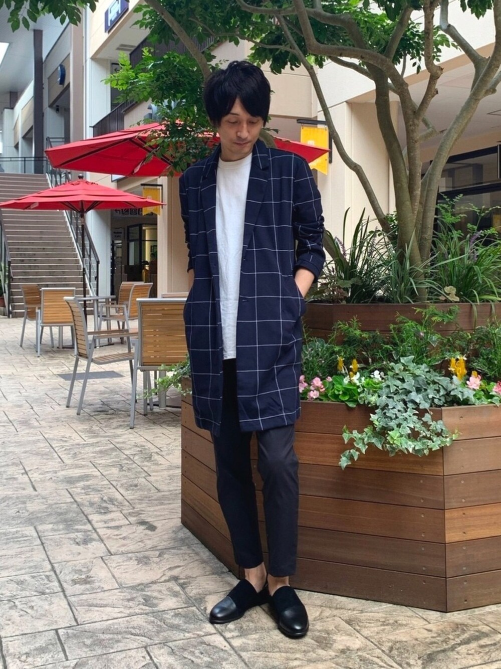 ブルー系のチェスターコート、ブラック系のスラックス、ブラック系のスリッポンを着用したメンズの秋コーディネートの1枚目の写真