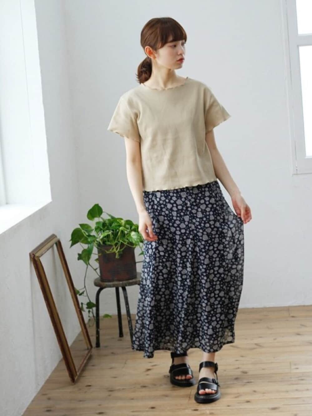 ベージュ系のTシャツ/カットソー、ブラック系のサンダル、ブルー系のスカートを着用したレディースの夏コーディネートの1枚目の写真