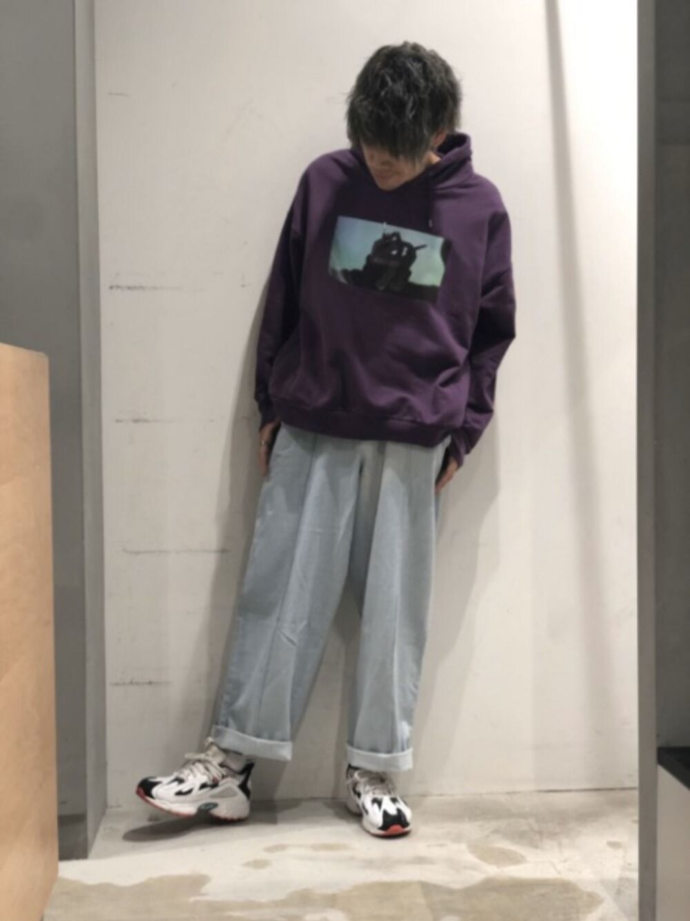 パープル系のパーカー、ブルー系のデニムパンツ、ホワイト系のスニーカーを着用したメンズの秋コーディネートの1枚目の写真