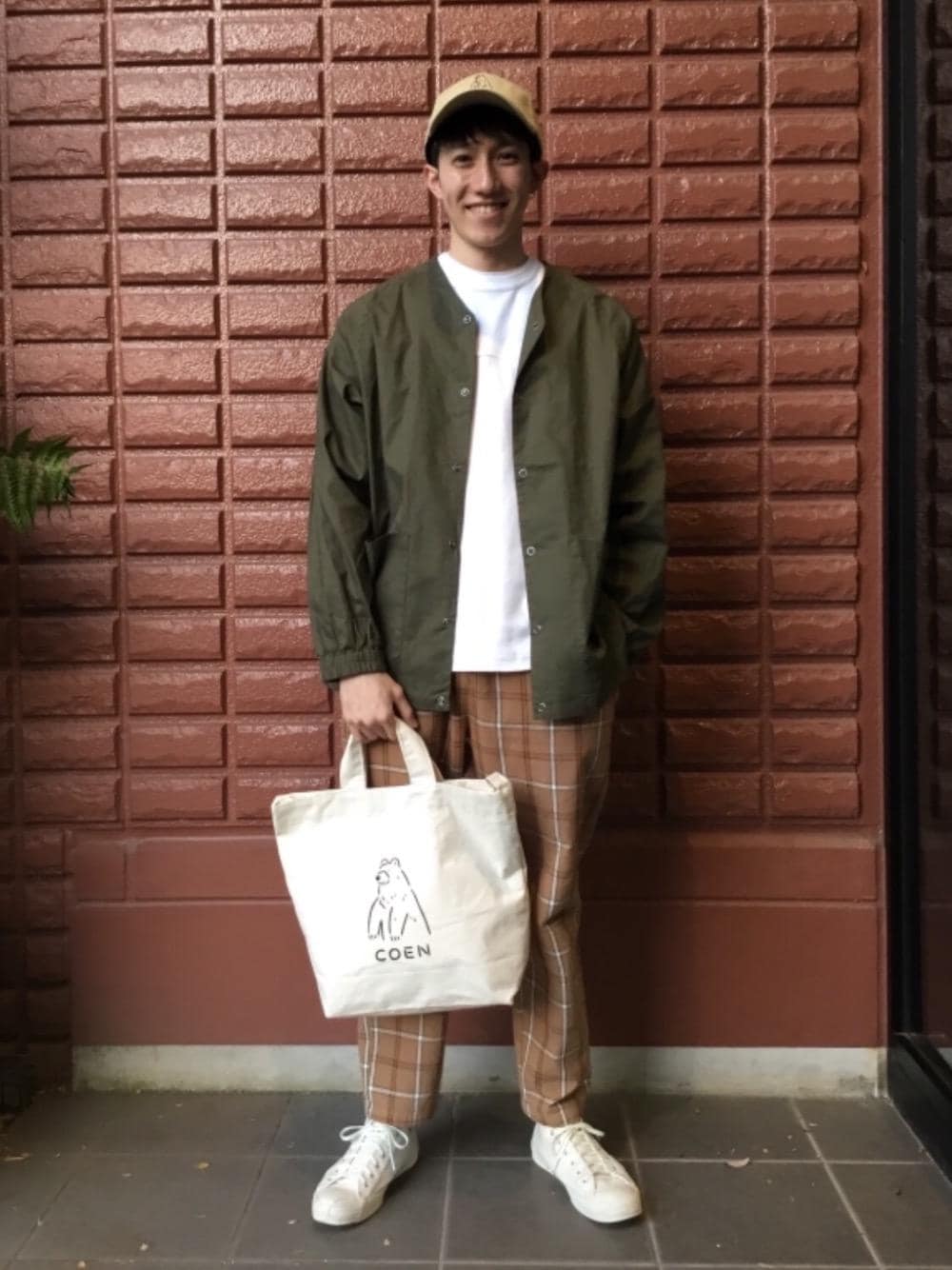 その他のトートバッグ、ブラウン系のその他パンツ、ホワイト系のTシャツ/カットソーを着用したメンズの春コーディネートの1枚目の写真