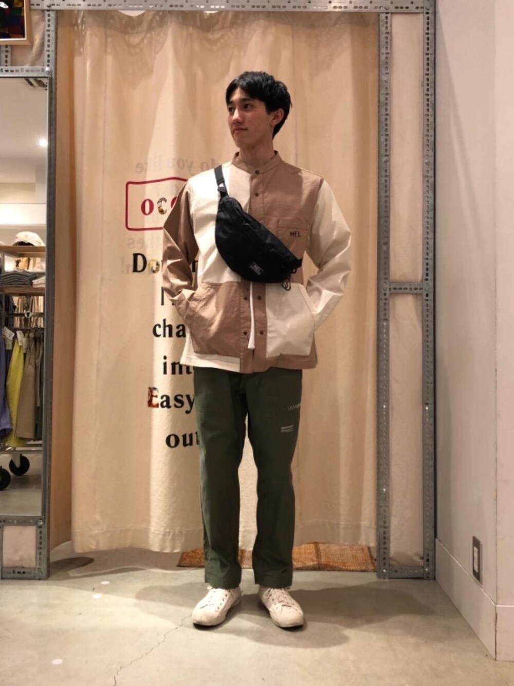 グリーン系のその他パンツ、ブラック系のボディバッグ/ウエストポーチ、ホワイト系のTシャツ/カットソーを着用したメンズの春コーディネートの1枚目の写真