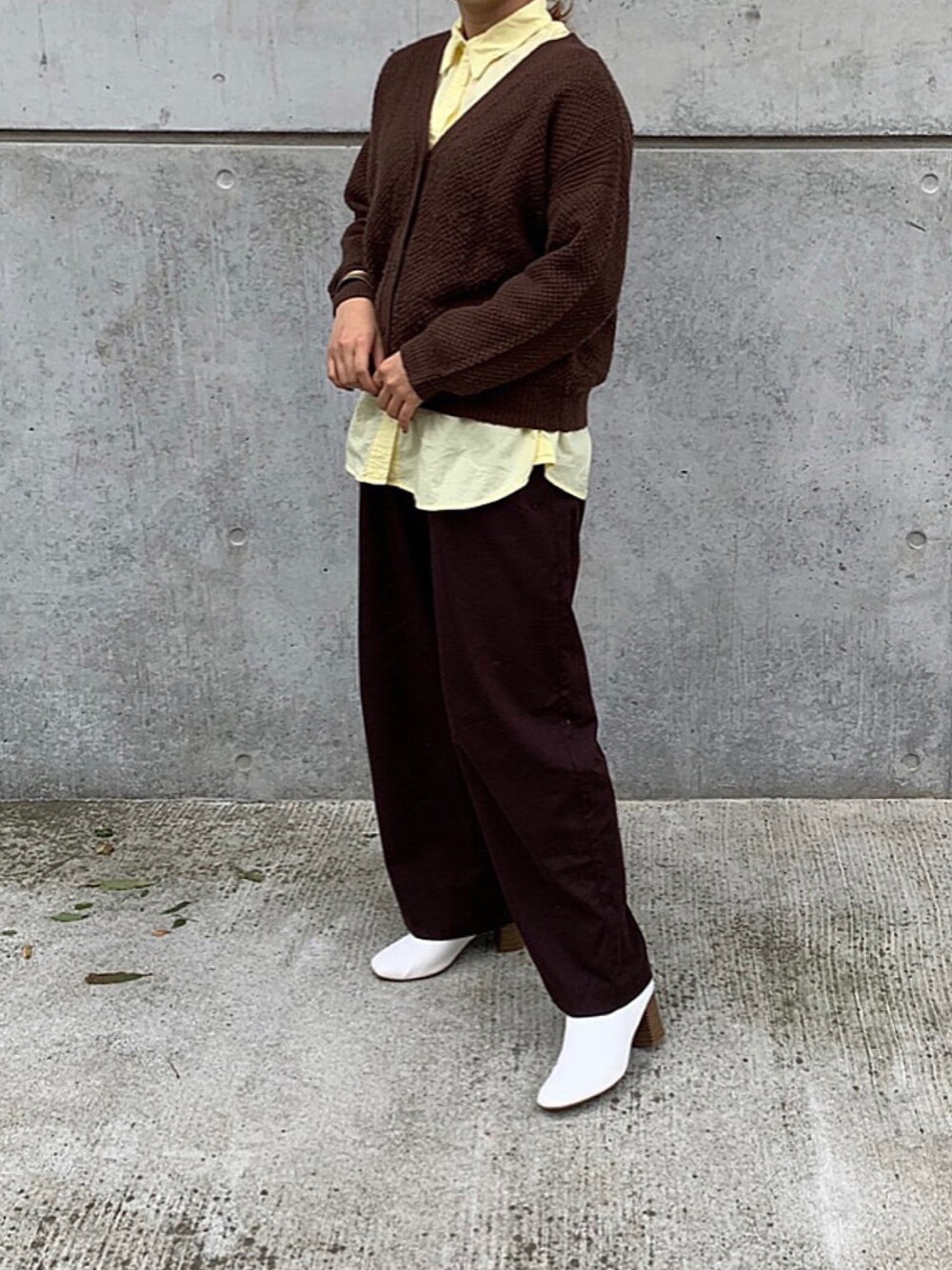 イエロー系のシャツ/ブラウス、ブラウン系のその他パンツ、ホワイト系のブーティを着用したレディースの秋コーディネートの1枚目の写真