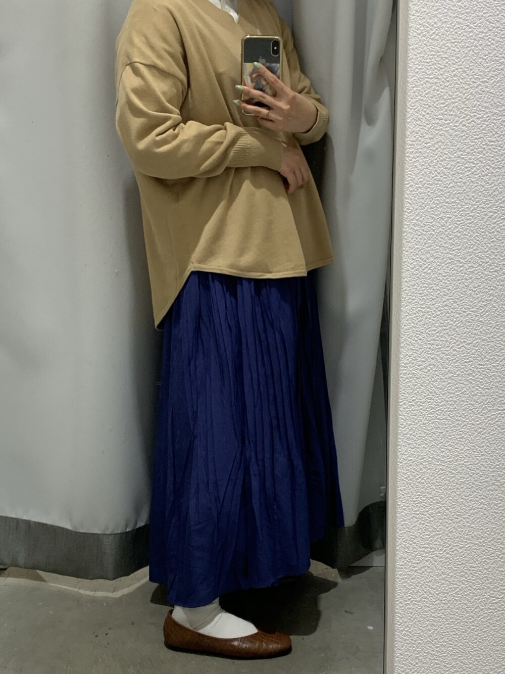 ブルー系のスカート、ベージュ系のニット/セーターを着用したレディースの春コーディネートの1枚目の写真