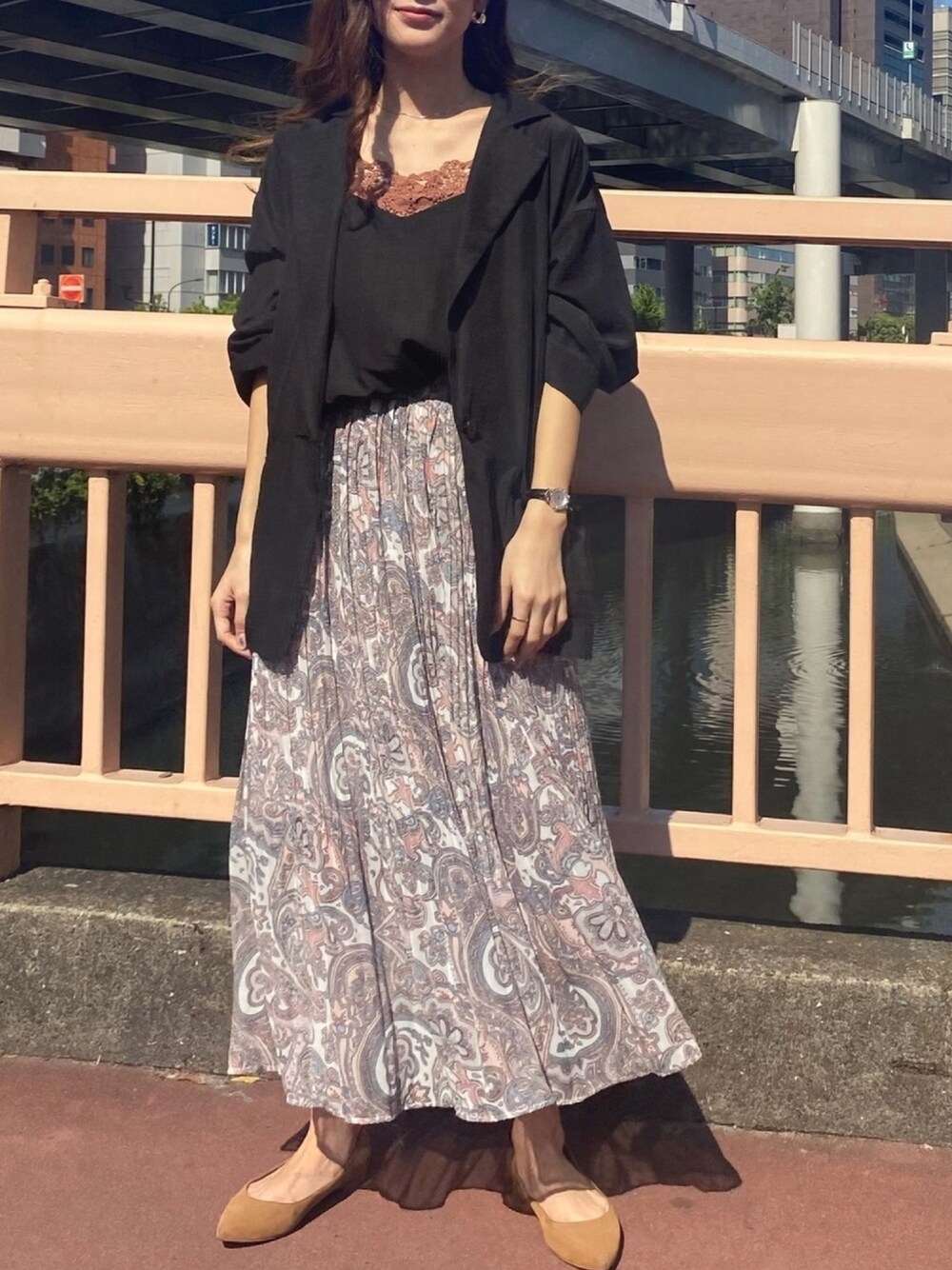 ピンク系のスカート、ブラック系のテーラードジャケットを着用したレディースの夏コーディネートの1枚目の写真