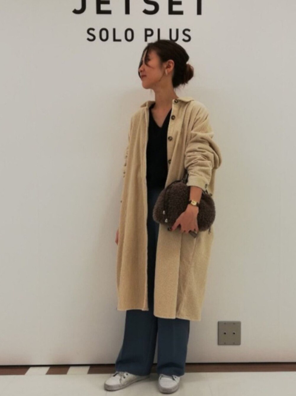 グレー系のショルダーバッグ、ホワイト系のシャツワンピース、ブルー系のその他パンツを着用したレディースの秋コーディネートの1枚目の写真
