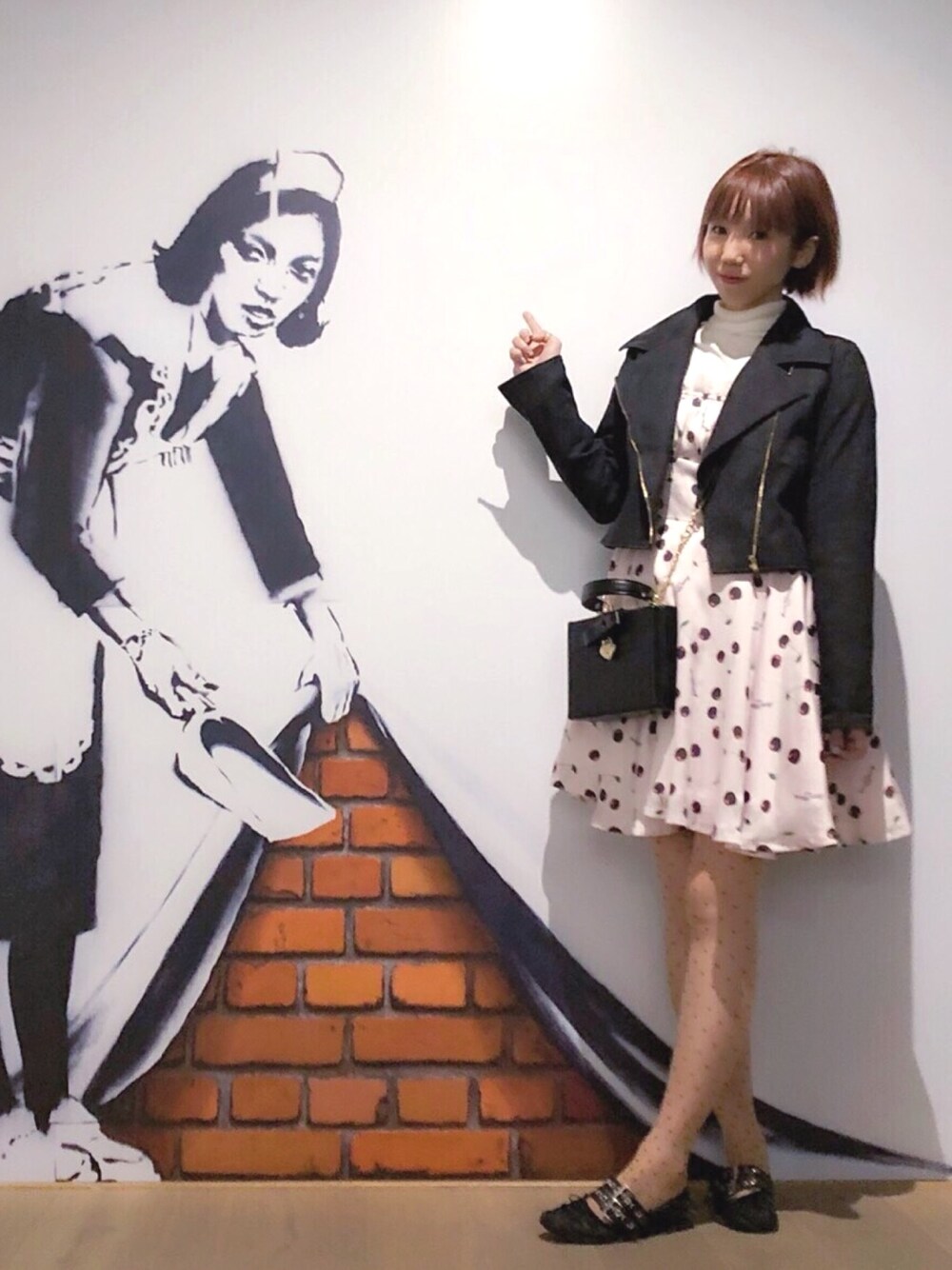 ブラック系のショルダーバッグ、ピンク系のワンピース、ブラック系のライダースジャケットを着用したレディースの夏コーディネートの1枚目の写真