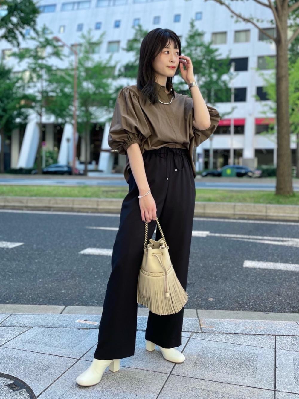 グリーン系のシャツ/ブラウス、ベージュ系のブーツ、シルバー系のブレスレットを着用したレディースの夏コーディネートの1枚目の写真